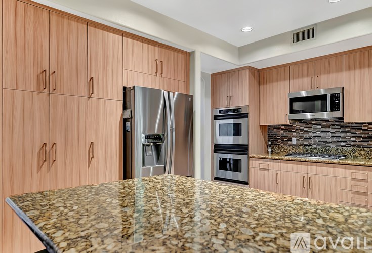A kitchen with wooden cabinets and a granite countertop.