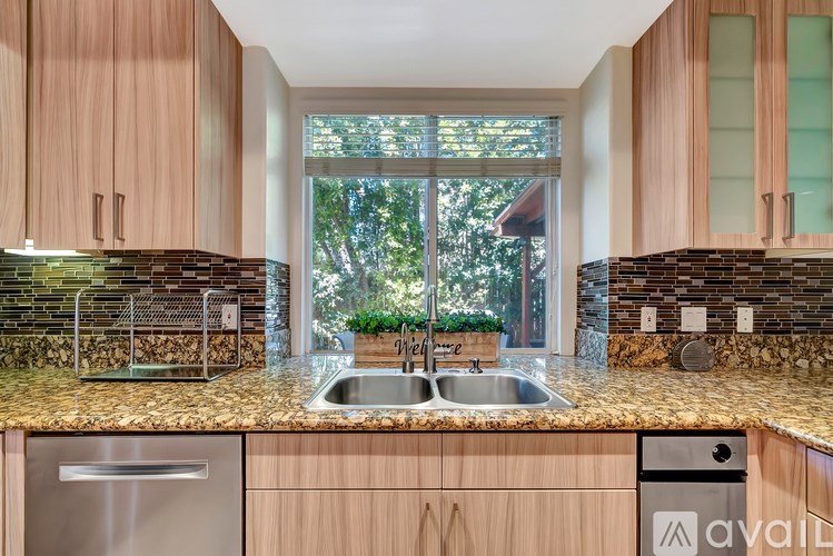 A kitchen with wooden cabinets and a granite countertop.