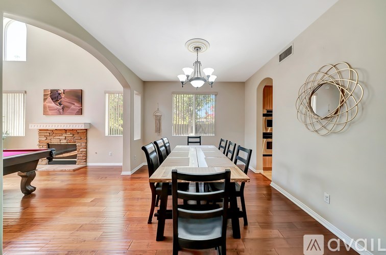 A large dining room with a pool table and a fireplace.