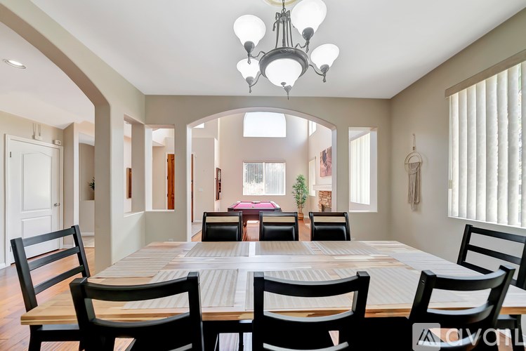 A dining room with a large table and chairs.