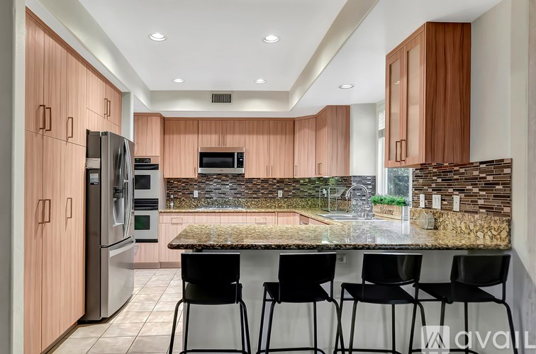 A kitchen with a refrigerator, oven, and microwave.