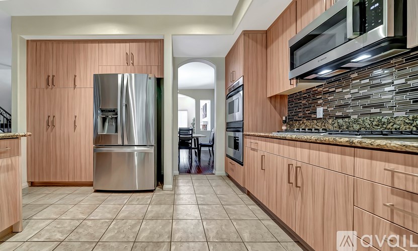 A kitchen with wooden cabinets and a stone backsplash.