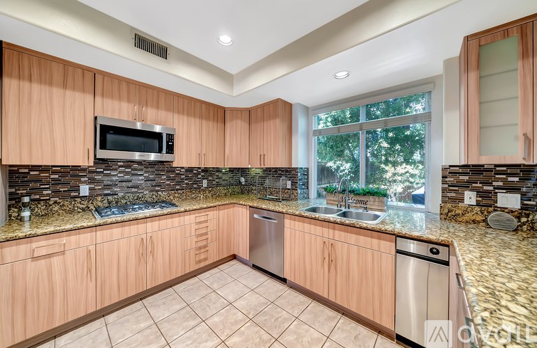 A kitchen with wooden cabinets and a stone backsplash.