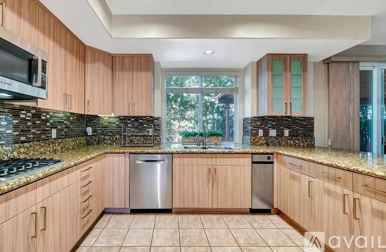 A kitchen with wooden cabinets and a stone backsplash.