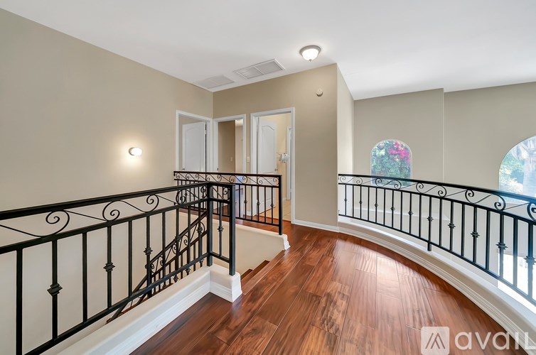 A staircase with a black railing and wooden steps.