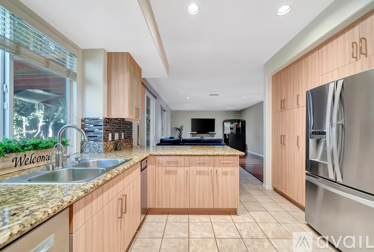 A kitchen with wooden cabinets and a granite countertop.