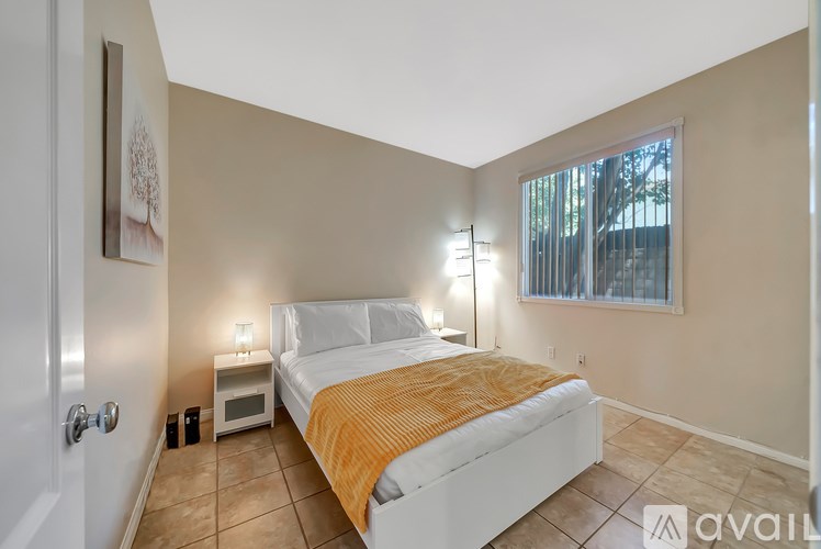 A bedroom with a bed, nightstand, and lamp.