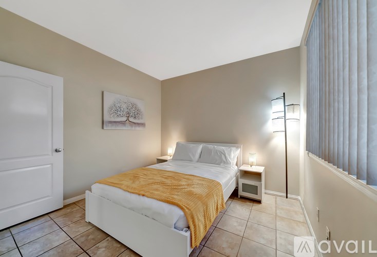 A bedroom with a bed, nightstand, and lamp.