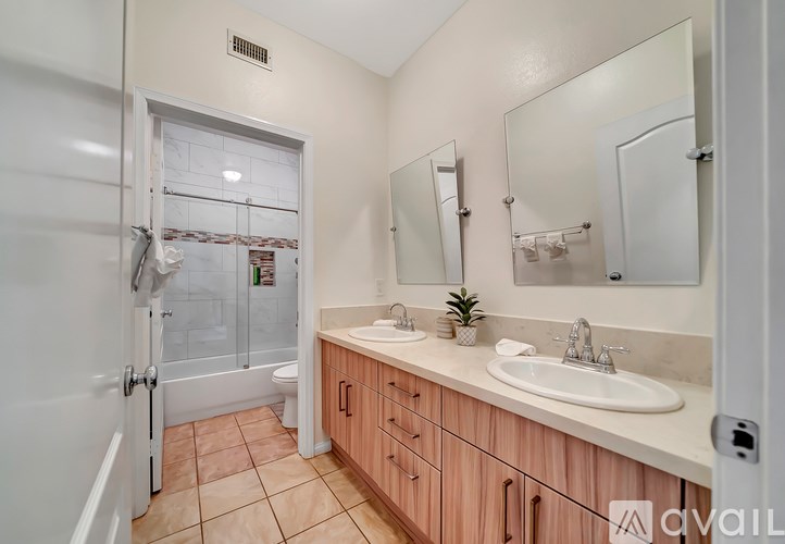 A bathroom with a sink, mirror, and shower.