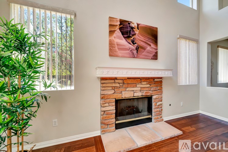 A living room with a fireplace and a painting on the wall.