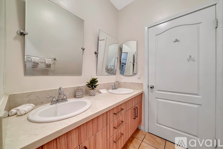 A bathroom with a sink, mirror, and a white door.