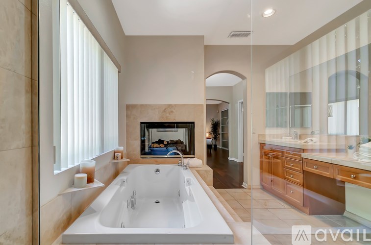 A modern bathroom with a large tub and a fireplace.