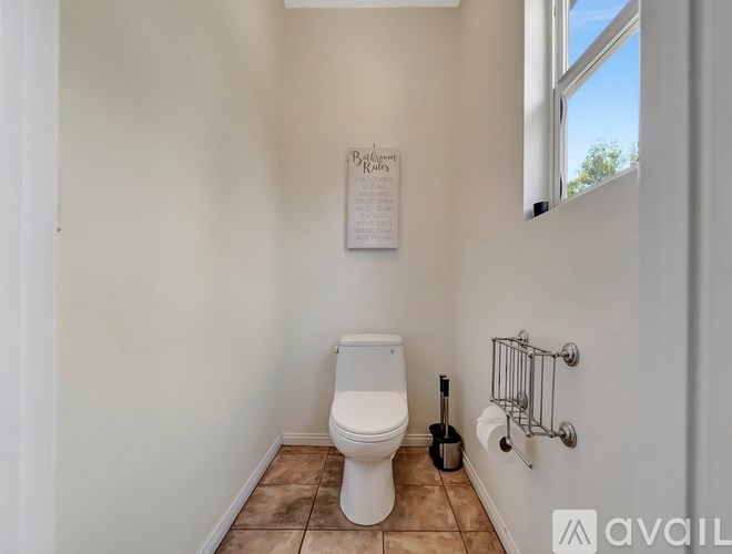 A bathroom with a toilet, a guitar and a sign on the wall.
