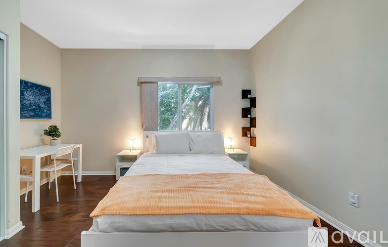 A bedroom with a bed, desk, and chair.