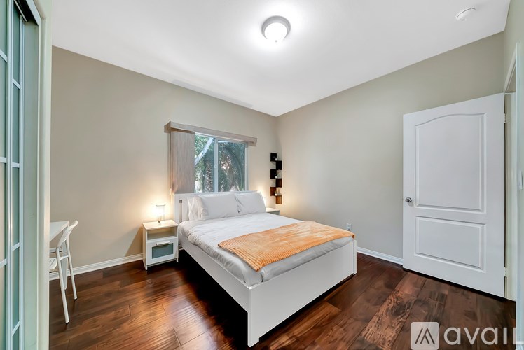 A bedroom with a bed, a chair, and a window.