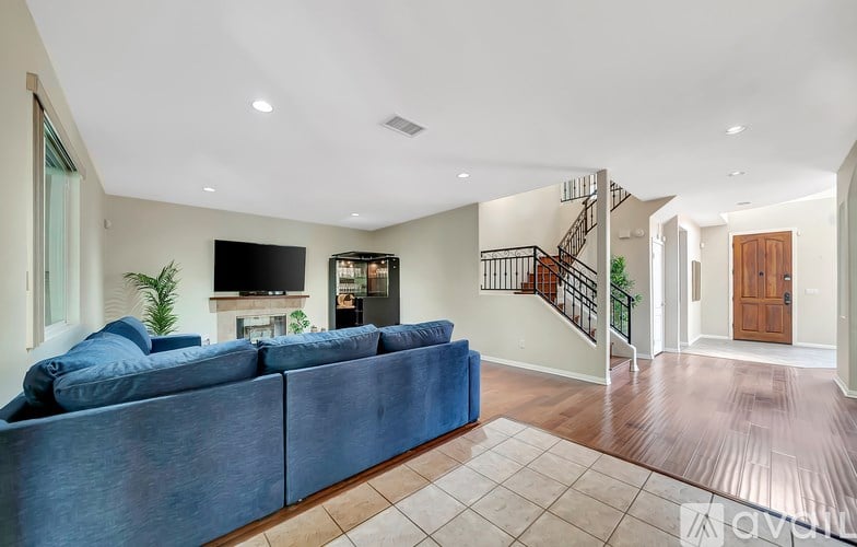 A living room with a blue couch and a television.