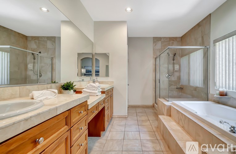 A modern bathroom with a large tub and double sinks.