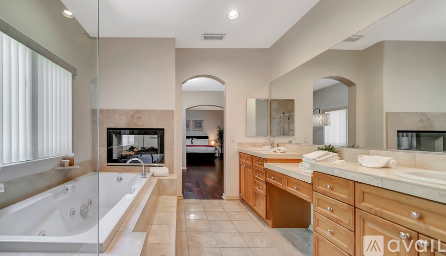 A large, modern bathroom with a tub, sink, and mirror.