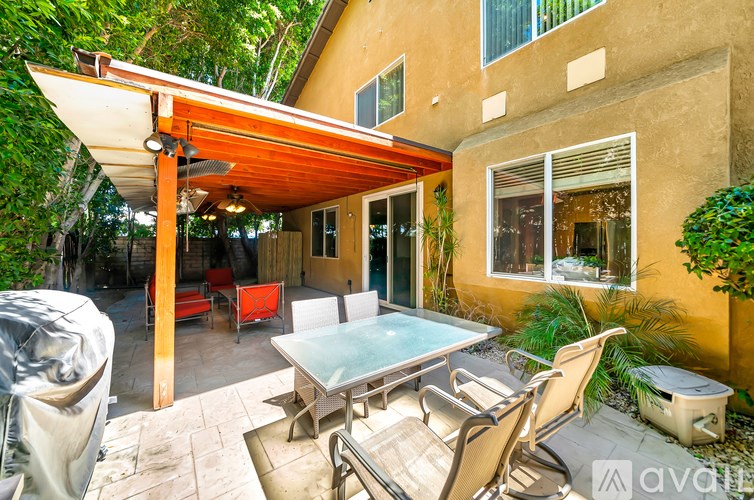 A patio with a table and chairs under a roof.