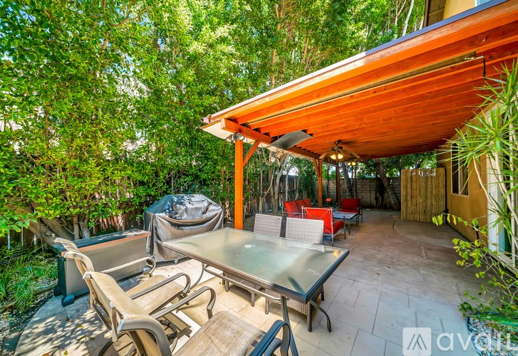 A patio with a table and chairs under a roof.