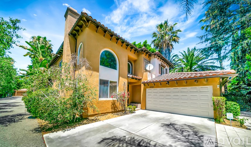 A house with a white garage door and a brown roof.