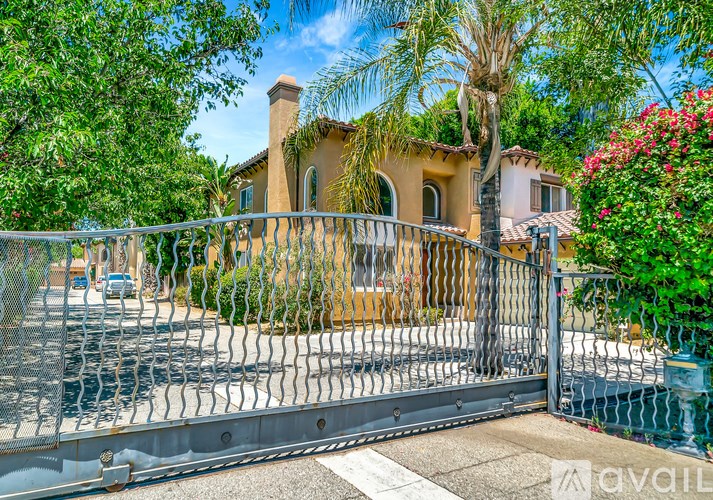 A house with a fence and gate in front of it.
