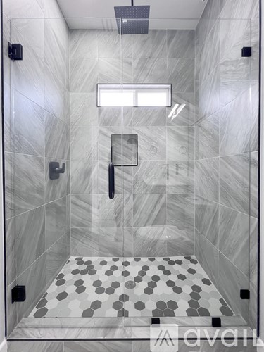 A modern bathroom with a walk-in shower and a tiled floor.