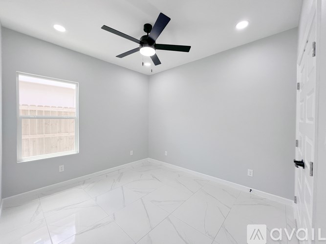 A room with a ceiling fan and a window.