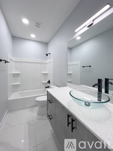 A bathroom with a white toilet, a sink, and a mirror.