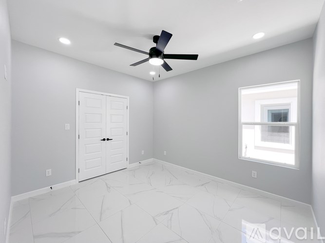 A room with a ceiling fan and a window.