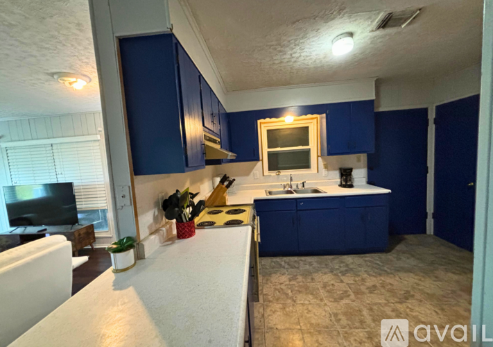 A kitchen with blue cabinets and a white countertop.