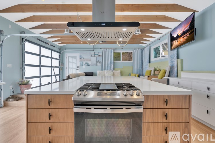 A modern kitchen with a stove top oven and wooden cabinets.