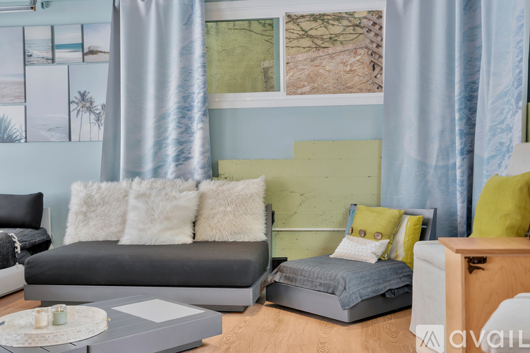 A living room with a grey couch and a grey sofa bed.