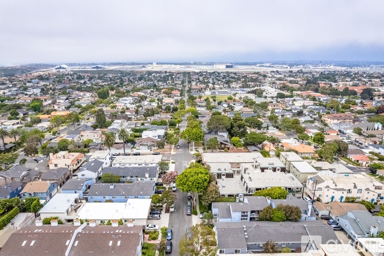A view of a city from above with buildings, cars, and trees.