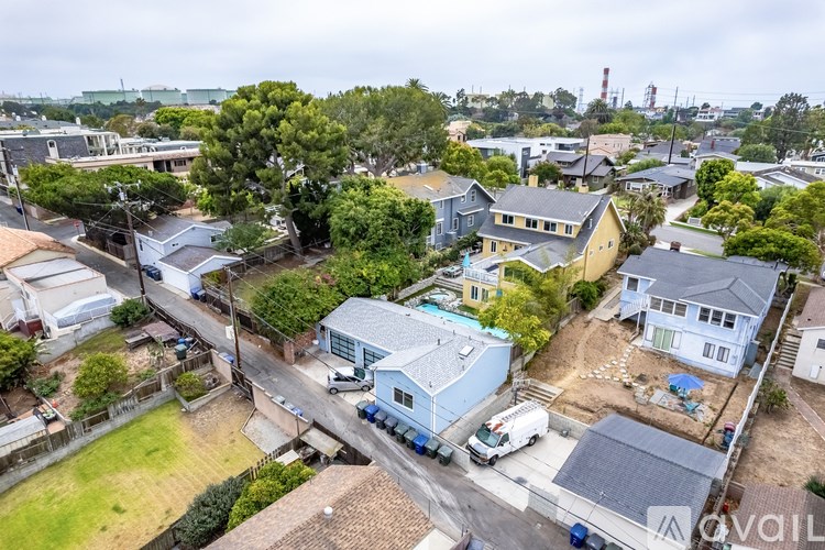 A bird's eye view of a residential area with houses and parked cars.