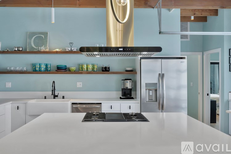 A modern kitchen with a large island and stainless steel appliances.