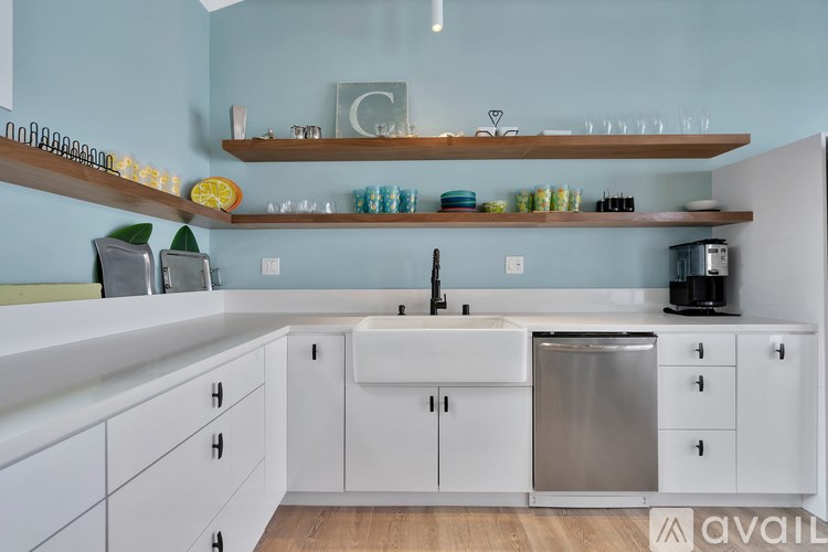 A kitchen with white cabinets and a stainless steel dishwasher.