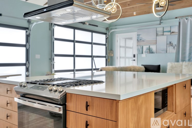 A kitchen with a stove top oven and wooden cabinets.