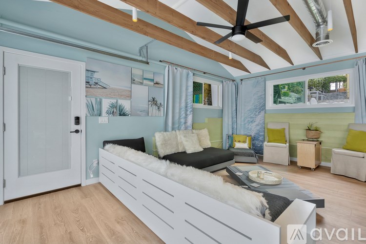 A room with a white bed and a ceiling fan.