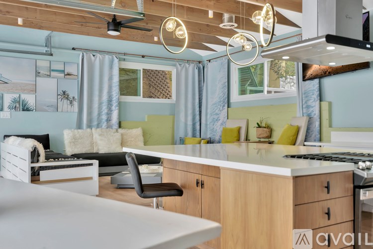 A modern kitchen with a dining area and a living room area.