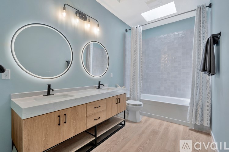 A bathroom with a double sink vanity and a shower area.