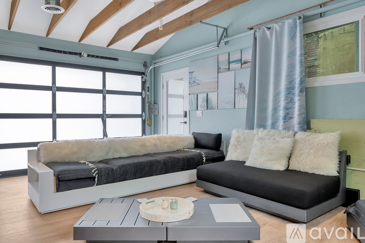 A modern living room with a large window and a grey sofa.