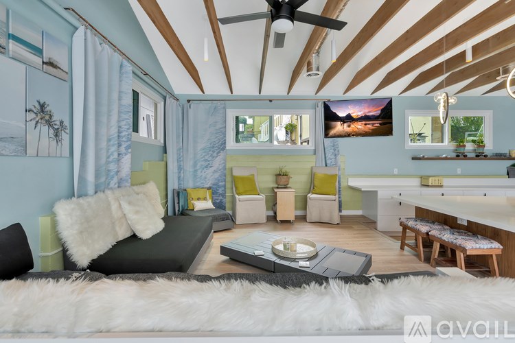 A living room with a grey couch and a white rug.