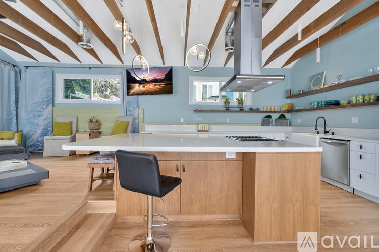 A kitchen with a large island and a black chair.