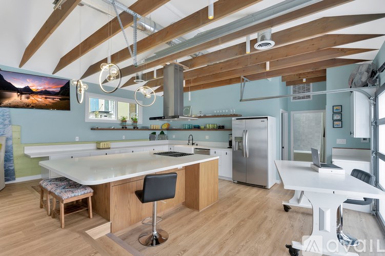 A modern kitchen with a large island and wooden floors.