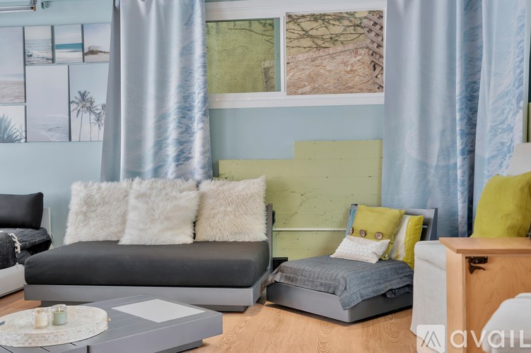 A living room with a grey couch and a grey sofa bed.