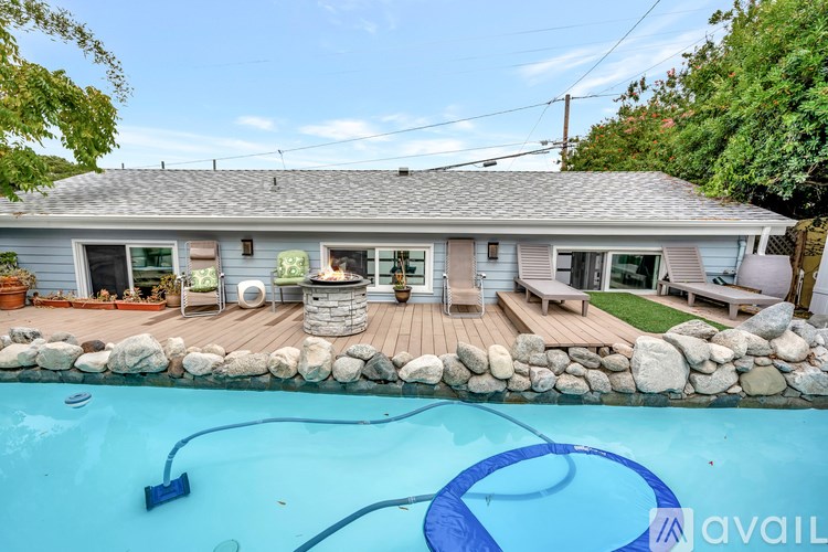 A house with a pool in front of it is for sale.