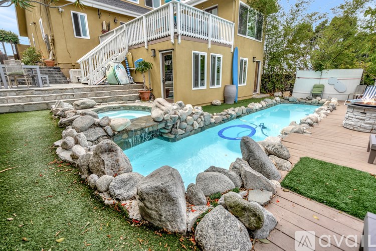 A yellow house with a pool in the backyard.