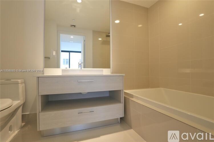 A bathroom with a white vanity and a bathtub.