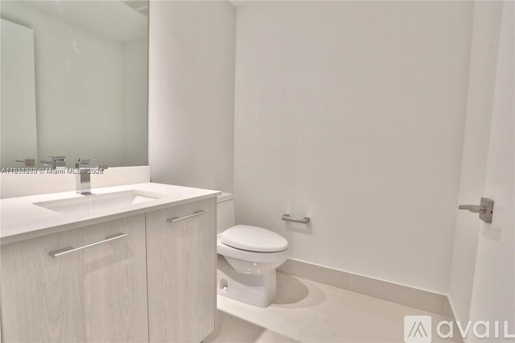 A white bathroom with a toilet and sink.